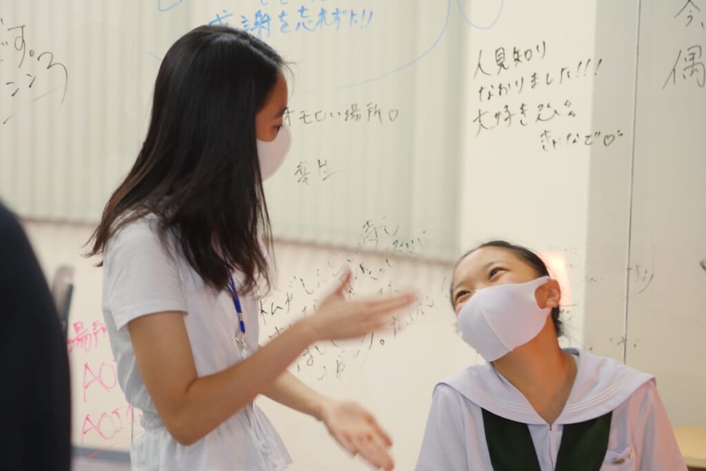 総合型選抜専門塾AOIの校舎で、メンターと生徒が志望理由について話している様子